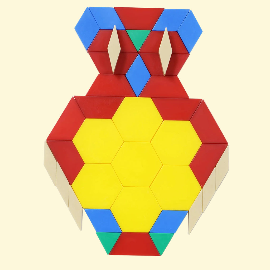 A colorful geometric block puzzle or toy structure assembled into a symmetrical vase-like shape, featuring a large yellow central hexagon area surrounded by red, blue, green, and beige pieces, photographed on a butter background.