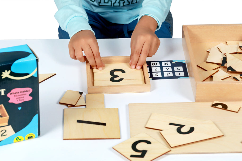 Child playing with toddlr's number architect (wooden number blocks) on a table