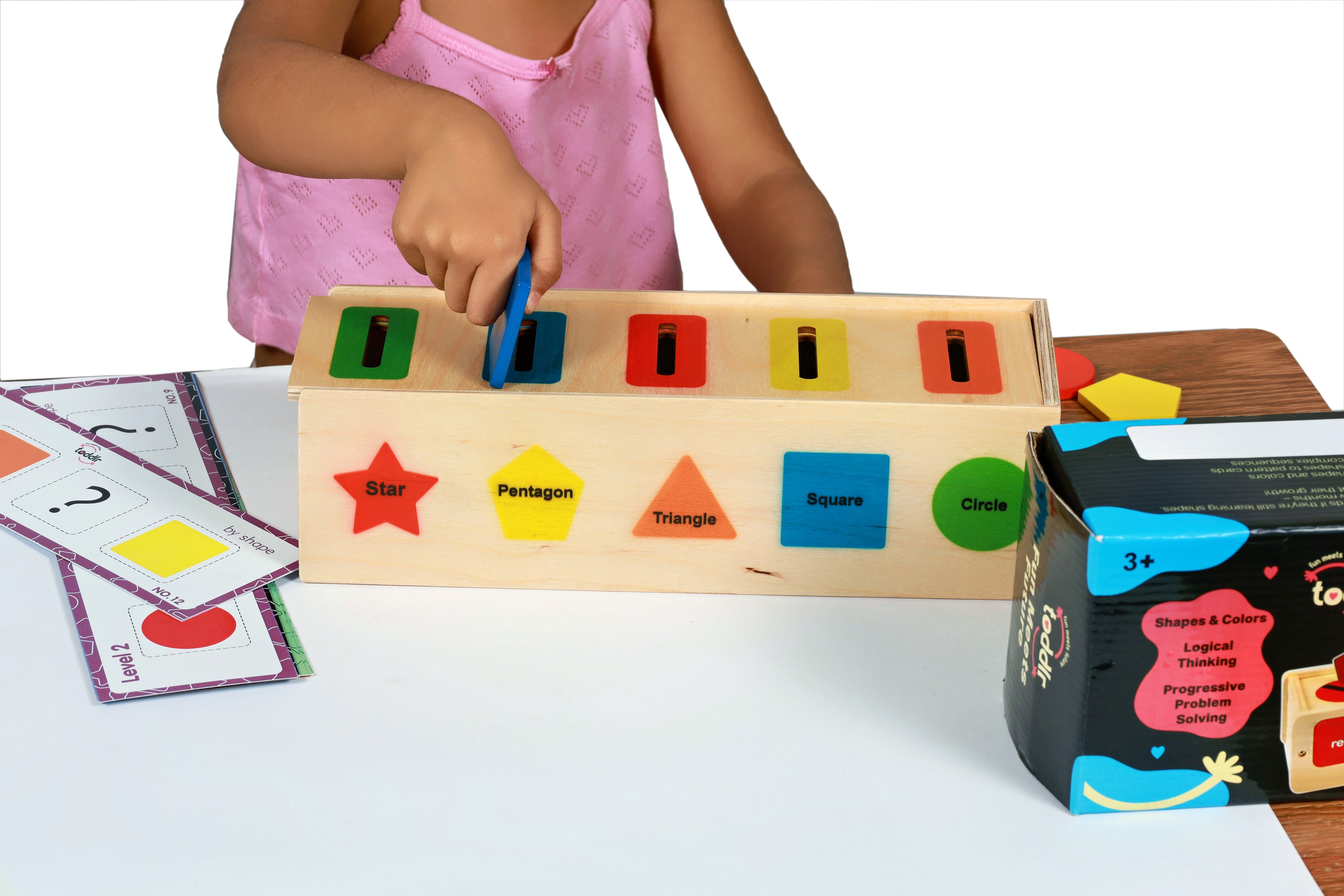 Child playing with toddlr's shape sorting toy on a white background